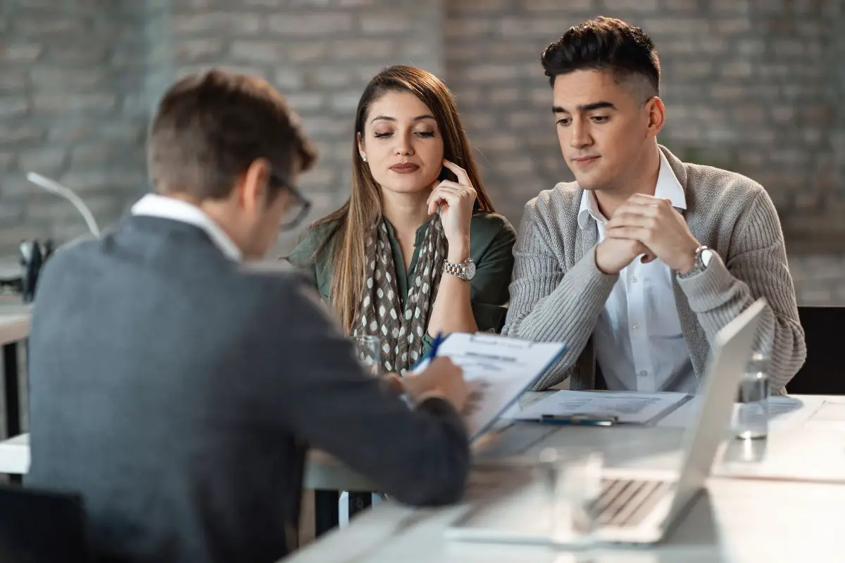 Des étudiants Analysant Le Plan De Remboursement De Leur Prêt Avec L'agent