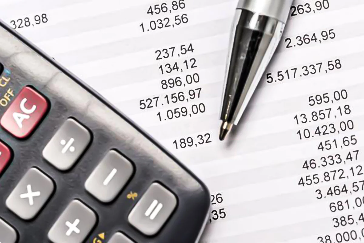 Calculatrice et stylo sur un document financier, représentant l'évaluation fiscale pour les bénéficiaires d'une assurance-vie.