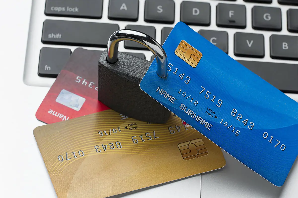 Cadenas sur un clavier d'ordinateur avec des cartes de crédit empilées, symbolisant la sécurité bancaire.