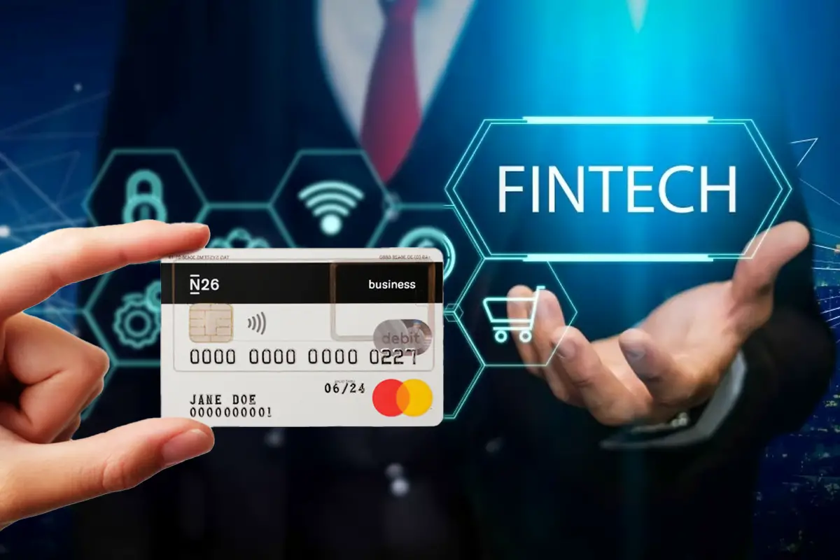Carte de débit N26 tenue à la main sur fond de technologie financière évoquant l'accès facilité aux services bancaires grâce à la Fintech.
